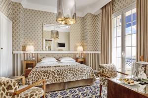 a bedroom with a bed and a large mirror at Hôtel Belles Rives in Juan-les-Pins