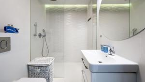 a white bathroom with a sink and a shower at Nad Zalewem, Sun & Snow in Dziwnówek