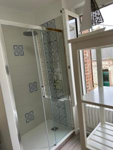 a shower with a glass door in a bathroom at Villa Roc Vaudieu - Charmante maison de pêcheurs in Étretat +33 photos