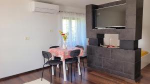 a dining room with a table and chairs and a television at Mar Apartments in Portorož +25 photos