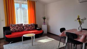 a living room with a red couch and a table at Mar Apartments in Portorož