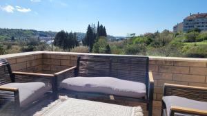 a balcony with two benches and a view of the city at Mar Apartments in Portorož