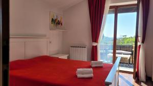 a bedroom with a red bed and a large window at Mar Apartments in Portorož