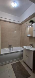 a bathroom with a bath tub and a sink at Apartament COSTA in Mamaia