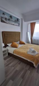 a bedroom with a large bed with a wooden floor at Apartament COSTA in Mamaia