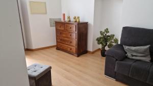 a living room with a couch and a dresser at Casa das Amas do Cardeal in Évora
