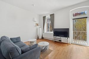 a living room with a couch and a tv at Ocean Breeze Residence - Nahe Uni & Zentrum in Dresden