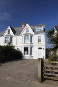 a large white house with a palm tree in front of it at Cliff House, Cornwall in Padstow
