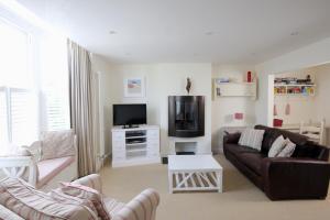 a living room with a couch and a tv at Cliff House, Cornwall in Padstow