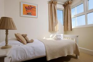 a bedroom with a white bed with teddy bears on it at Cliff House, Cornwall in Padstow