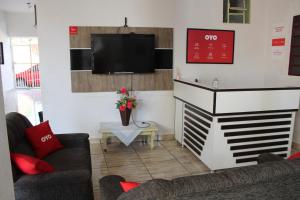 a living room with two couches and a flat screen tv at OYO Pousada Paraná, Cuiabá in Cuiabá