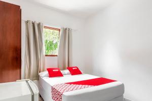 two beds in a room with red pillows at OYO Pousada Tia Léo Campinas in Campinas