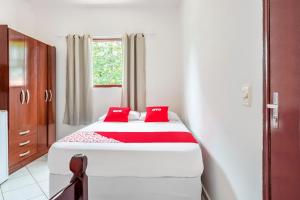 a bedroom with a bed with two red pillows at OYO Pousada Tia Léo Campinas in Campinas +28 photos