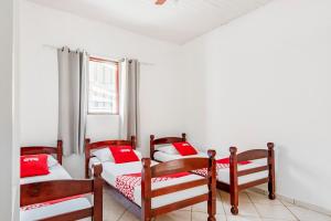a room with three bunk beds with red pillows at OYO Pousada Tia Léo Campinas in Campinas