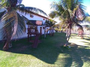 a house with two palm trees in the yard at OYO Pousada do Wagner, Rio das Ostras in Rio das Ostras