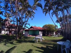 a resort with palm trees in the yard at OYO Pousada do Wagner, Rio das Ostras in Rio das Ostras