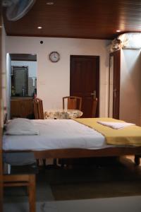 a bedroom with a bed and a clock on the wall at Dreams Valley in Kadavoor