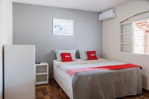 a bedroom with a bed with red pillows on it at OYO M&J Hotel in Santo Antônio do Descoberto +16 photos