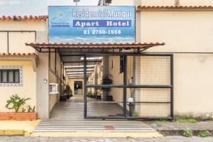 an entrance to an apartment building with a sign on it at OYO Residencial Muriqui Apart Hotel, Mangaratiba in Vila Muriqui