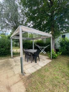 - un abri de pique-nique avec une table et des chaises dans la cour dans l'établissement Mobilhome Île d Oléron Camping Les Tamaris, à Saint-Pierre-dʼOléron 2 autres photos