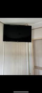 a flat screen television hanging from a ceiling in a room at PG177 Golden Palm Resort 8 Berth Caravan With Decking in Chapel Saint Leonards +9 photos