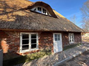 an old brick house with a thatched roof at Oolt Huus No 2 I exklusives Wohnen im denkmalgeschützten Reetdachhaus in Sievern