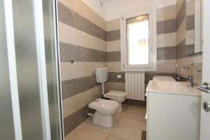 a bathroom with a toilet and a sink at Regina Mare in Lido degli Scacchi +18 photos