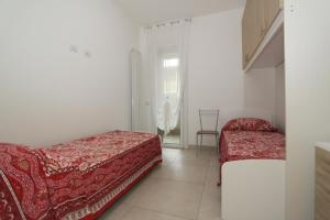 a bedroom with two beds and a chair in it at Regina Mare in Lido degli Scacchi
