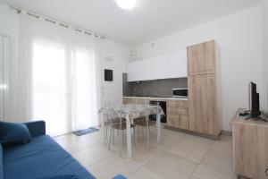 a living room with a blue couch and a kitchen at Regina Mare in Lido degli Scacchi