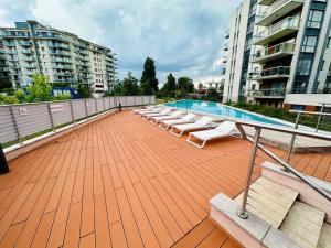 a swimming pool with lounge chairs on a patio at Dunai panoráma in Budapest