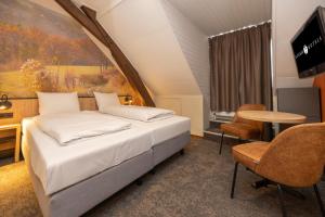 a hotel room with a bed and a table at Fletcher Hotel Restaurant De Burghoeve in Valkenburg