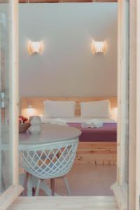 Schlafzimmer mit einem Bett mit einem Tisch und einem Tisch in der Unterkunft Coastal Cottage Chic House in Vlikhón