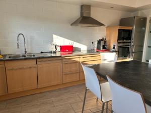 a kitchen with a sink and a table with chairs at O'Calm - Gite A-2h wellness par nuitée à réserver in Jenneville