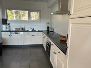 a kitchen with white cabinets and black counter tops at Ocalm gîte B-2h wellness par nuitée à réserver in Libramont +16 photos