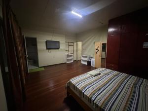 Spacious 4-Bedroom Family Home في باراماريبو: غرفة نوم مع سرير وتلفزيون بشاشة مسطحة