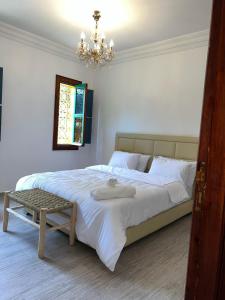 a bedroom with a large bed with a chandelier at Riad For families and groups in Marrakech +11 photos