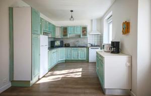 a kitchen with green cabinets and a white refrigerator at 3 Bedroom Stunning Home In Plougasnou in Plougasnou