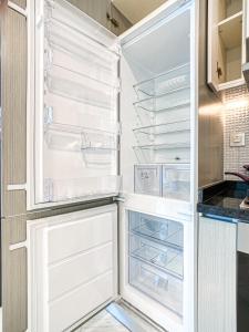 an empty refrigerator with its door open in a kitchen at Chic Urban Escape 1BR -Sleeps 4- in Bayz by Danube-18 in Dubai