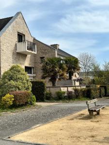 un banc assis sur le côté d'une route devant un bâtiment dans l'établissement Carnac joli appartement entre plage et ville!, à Carnac