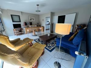 un salon avec un canapé bleu et une table dans l'établissement Carnac joli appartement entre plage et ville!, à Carnac
