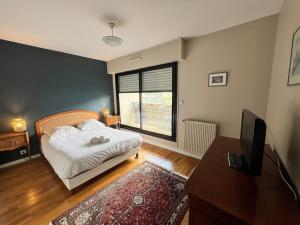 une chambre avec un lit et un bureau avec une télévision dans l'établissement Carnac joli appartement entre plage et ville!, à Carnac