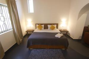 Vera Dune في كاندوليم: غرفة نوم بسرير ومخدات صفراء ونافذة