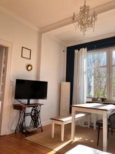 ein Wohnzimmer mit einem Tisch und einem TV in der Unterkunft Lindas Diekblick, 2 Schlafzimmer, EG mit Terrasse in Elsfleth