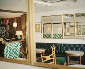 a mirror reflection of a bar with a table and chairs at H&ocirc;tel du Temps in Paris