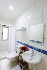 La salle de bains est pourvue de toilettes blanches et d'un lavabo. dans l'établissement Love B&B, à Sanyi
