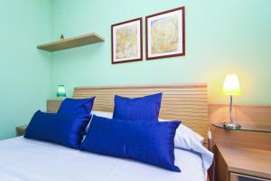a bedroom with blue pillows on a white bed at Cabo Menor 2 Planet Costa Dorada in Salou +24 photos
