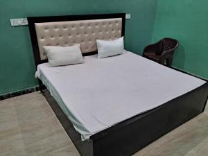 una cama con dos almohadas encima en Anuj Palace, en Ayodhya