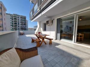 un patio con mesa y banco en un edificio en Primavera 2-1, en Lido di Pomposa