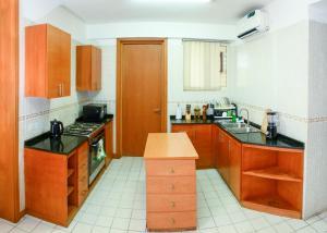 a kitchen with wooden cabinets and a stove top oven at Pentridge 3-Bed Haven in Lagos