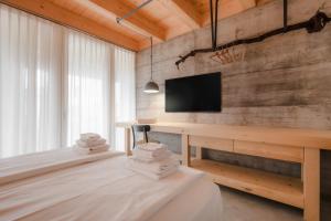 a room with two beds and a desk with a tv at Villa del Brolo - Famiglia Furia in Mezzane di Sotto